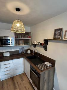 a kitchen with a sink and a stove top oven at Les Volets Bleus house and spa in Jublains +30 photos