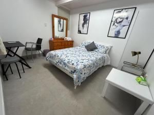 a bedroom with a bed and a table and a desk at Rest & Relax Holiday Home in Whangarei