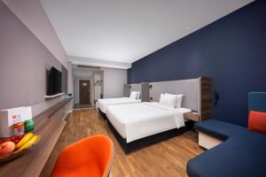 西安西安钟楼智选假日酒店的酒店客房设有两张床和一张带一碗水果的桌子。 更多109张照片