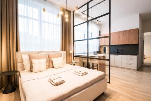 a bedroom with a large bed and a kitchen at Apartmány Ružomberok in Ružomberok