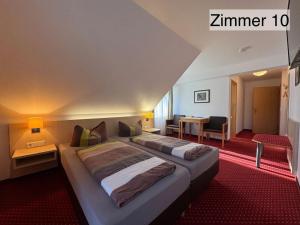 a hotel room with two beds and a desk at Landgasthof Rössle in Kressbronn am Bodensee