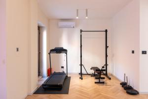 een kamer met een fitnessruimte met een loopband en een spiegel bij MIA HOME experience in Milaan