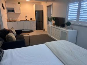 Habitación con cama y sala de estar con cocina. en Studio by the bays, en Auckland