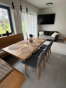 a wooden table and chairs in a living room at Apartmán u Dolní Moravy in Prostřední Lipka