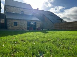 a building with a grass field in front of it at Les Volets Bleus house and spa in Jublains