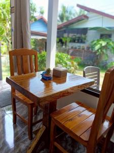 a wooden table and two chairs on a porch at เจ๊สวนบังกะโล in Ban Dan Mai