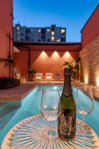 een fles wijn en twee wijnglazen op een tafel bij MIA HOME experience in Milaan