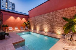 een zwembad voor een bakstenen muur met verlichting bij MIA HOME experience in Milaan