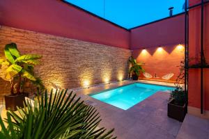 een zwembad in een achtertuin met een bakstenen muur bij MIA HOME experience in Milaan
