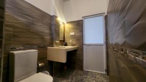 een badkamer met een wastafel en een toilet en een raam bij MobyDick House in Mirissa +42 foto's