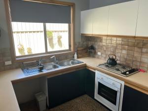 una cocina con fregadero y estufa horno superior en Central Comfort, en Shepparton