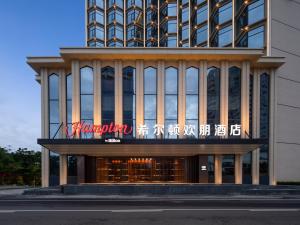a building with a sign in front of it at 海口国贸希尔顿欢朋酒店 in Haikou