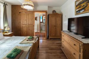 a bedroom with a bed and a flat screen tv at Hanga Vendégház Parád in Parád +33 photos