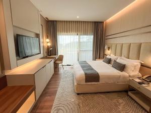 une chambre d'hôtel avec un lit et une télévision dans l'établissement The Lake Hotel Tagaytay, à Tagaytay