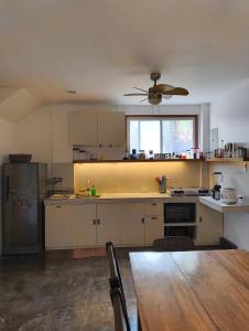 a large kitchen with a table and a ceiling fan at Casa del mar house in Paje +10 photos