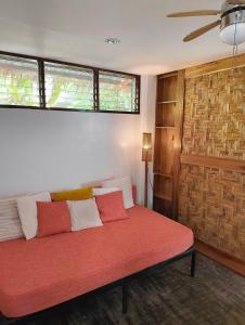 a red couch in a room with two windows at Casa del mar house in Paje