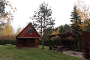a small cabin with a picnic table and a tent at Całoroczny, drewniany domek przy lesie in Prażmów