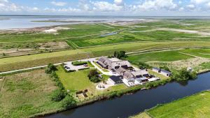 an aerial view of a large house on an island in the water at Nordsee-Hotel Arlau-Schleuse in Husum
