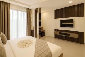 een hotelkamer met een bed en een televisie bij Hotel Zion Inn, Cantonment, Varanasi in Varanasi