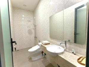 ein Badezimmer mit Toilette, Waschbecken und Spiegel in der Unterkunft Bao Ong Thien Retreat - Khu Nghỉ Dưỡng Bào Ông Thiền 