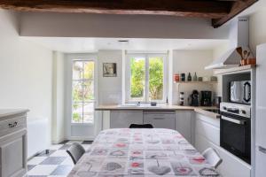 a white kitchen with a table with a pattern on it at maison Amboise in Limeray
