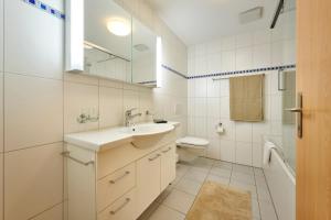 a white bathroom with a sink and a toilet at Great Location, Spacious, nice views, modern in Lauterbrunnen +35 photos