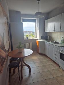 een keuken met een tafel en een tafel en een raam bij Apartament Zduńska in Włocławek