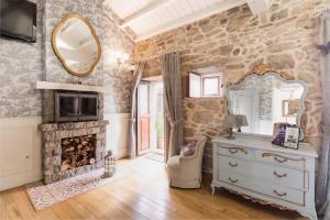 a room with a fireplace and a mirror and a dresser at Casa de Carmen in Corcubión