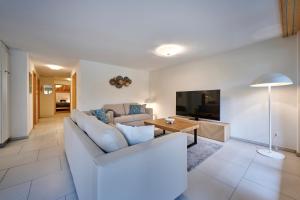 a living room with a couch and a table and a tv at Great Location, Spacious, nice views, modern in Lauterbrunnen