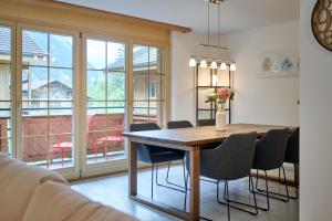 a dining room with a wooden table and chairs at Great Location, Spacious, nice views, modern in Lauterbrunnen