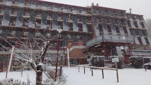 um grande edifício com neve em frente em Evenia Monte Alba em Cerler