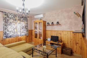 サン・ファン・デ・アスナルファラチェにあるSan Juan Bien Comunicadoのソファとテレビのあるリビングルーム