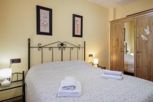 サン・ファン・デ・アスナルファラチェにあるSan Juan Bien Comunicadoのベッドとタオル2枚のある寝室