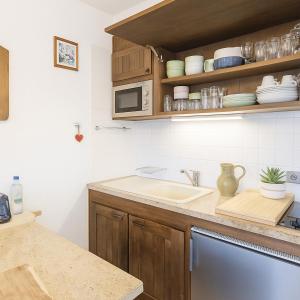 eine Küche mit Spüle und Mikrowelle in der Unterkunft Smartstay Caron - Val Thorens in Val Thorens
