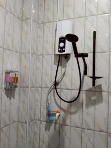 a shower with a blow dryer on a wall at เจ๊สวนบังกะโล in Ban Dan Mai