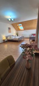 een woonkamer met een bed en een vaas met bloemen bij Rare Forest Retreat & Spa in Bran