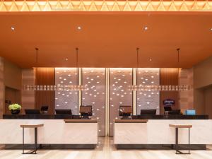 a lobby with a large glass wall with lights on it at 海口国贸希尔顿欢朋酒店 in Haikou