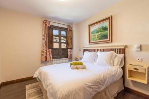 Un dormitorio con una cama con un osito de peluche encima. en Un duplex con encanto, en Jaca 18 fotos más