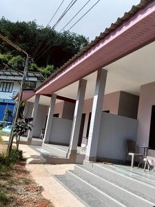 a house with white columns and a porch at เจ๊สวนบังกะโล in Ban Dan Mai