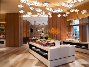 a lobby of a restaurant with a counter with food at 海口国贸希尔顿欢朋酒店 in Haikou