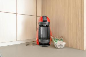 een rood en zwart koffiezetapparaat op een aanrecht bij City Oasis Studio in Oradea