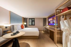 a hotel room with a bed and a television at Manxin Hotel Beijing Lama Temple in Beijing
