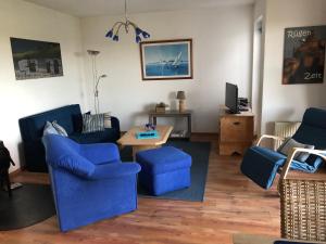 a living room with blue couches and a table at Ferienwohnung Schwalbennest in Zudar