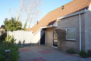 a brick house with a gate and a fence at Kustverhuur , Park Scheldeveste, Zwin 143 in Breskens
