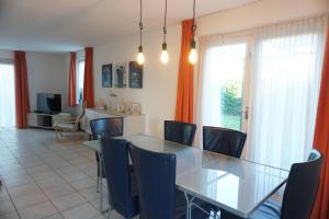a dining room with a glass table and chairs at Kustverhuur , Park Scheldeveste, Zwin 143 in Breskens