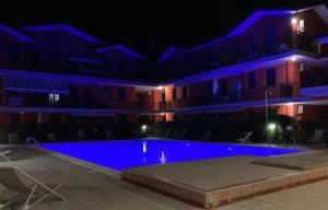 a swimming pool in front of a building at night at Green oasis close to the center in Rosolina Mare +13 photos