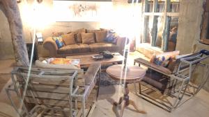 a living room with a couch and a table and chairs at Ou Kraal Tented Lodge in Boshoek