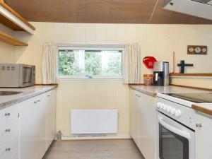 een keuken met witte apparatuur en een raam bij 4 person holiday home in Skjern in Skjern