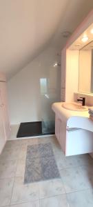 eine Küche mit weißen Schränken und einem Fliesenboden in der Unterkunft Maison charmante avec patio ! in Bourges