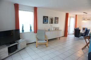 a living room with a television and a table and chairs at Kustverhuur , Park Scheldeveste, Zwin 143 in Breskens